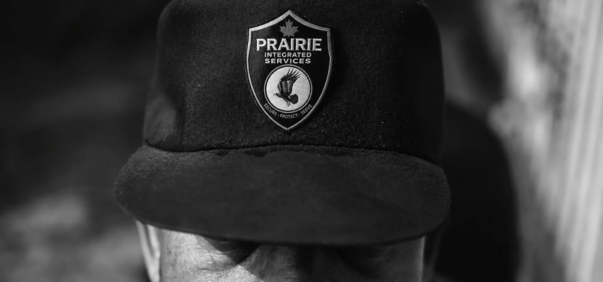 Close portrait of an officer wearing a cap badged with the Prairie Integrated Services crest.